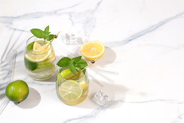 Детокс-вода с лимонным, лаймовым и мятным вкусом на легком фоне. Освежающий летний домашний лимонад-коктейль. Фруктовые соки и ингредиенты, концепции похудения, здоровая и натуральная пища - svetlanabalyn
