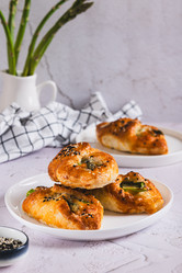 Вкусные слоеные булочки с сыром и спаржей на тарелке на столе (вид сверху) - Elena Rui