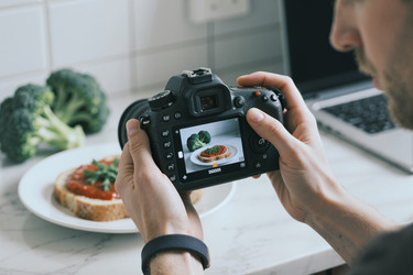Взрослый мужчина фотографирует еду для блога рецептов и социальных сетей - Mediaphotos