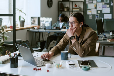 Взрослый мужчина, работающий на ноутбуке в среде стартапа creative office - AnnaStills