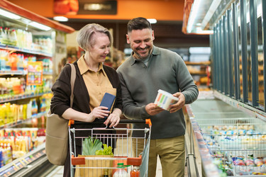 Пара средних лет покупает продукты в супермаркете - Pressmaster