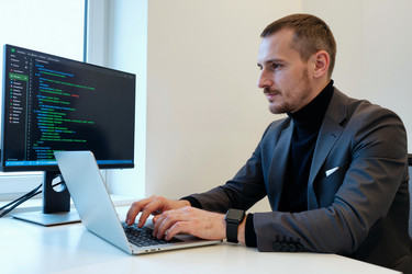 Взрослый мужчина кодирует на ноутбуке для рабочего процесса разработки программного обеспечения - AnnaStills