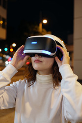 Взрослая женщина настраивает vr-гарнитуру для иммерсивных игр ночью - Mediaphotos