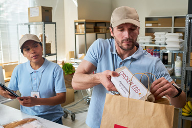Работники службы доставки упаковывают продуктовый заказ для самовывоза - Pressmaster