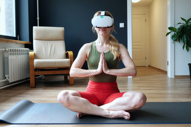 Взрослая женщина медитирует с vr-гарнитурой для хорошего самочувствия дома - AnnaStills