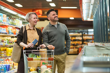 Взрослая пара покупает продукты в проходе супермаркета - Pressmaster