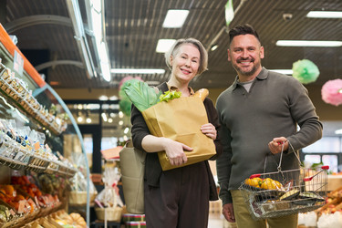 Портрет пары средних лет, покупающей продукты в супермаркете - Pressmaster