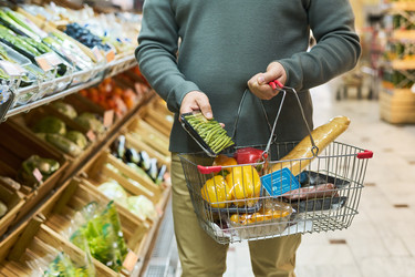Взрослый мужчина несет продуктовую корзину, выбирая свежие овощи - Pressmaster