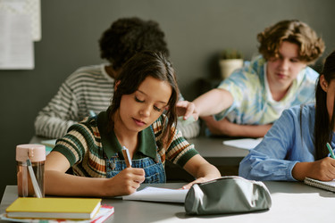 Разнообразные учащиеся-подростки готовят заметки в классе для достижения успеха в школе - AnnaStills
