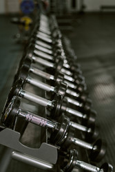 Гантели выстроились в ряд в тренажерном зале для маркетинга силовых тренировок - AnnaStills