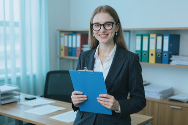 Портрет улыбающейся женщины с планшетом в руках в корпоративном офисе - DragonImagesAsia