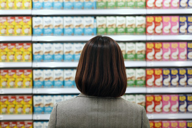 Вид сзади на азиатскую женщину, выбирающую продукты на полке супермаркета - Pressmaster
