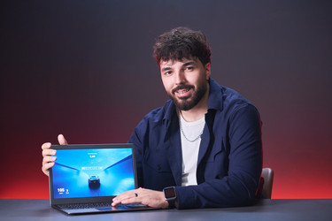 Портрет мужчины, представляющего ноутбук для продвижения игр - Pressmaster