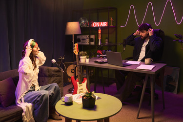 Молодые мужчина и женщина записывают подкаст в студии on Air - Pressmaster
