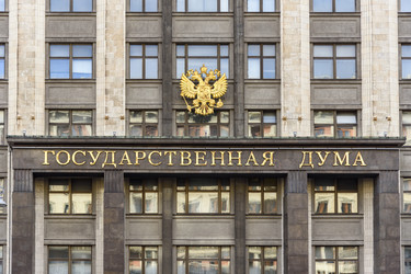 Фасад здания Государственной Думы России с гербом и золотой надписью в центре Москвы - Sadoff
