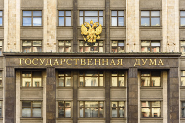 Фасад здания Государственной Думы России с гербом и золотой надписью в центре Москвы - Sadoff