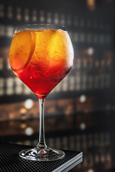 На барной стойке стоит бокал коктейля Aperol Spritz с апельсинами и кубиками льда. Итальянский напиток с низким содержанием алкоголя. Концепция летнего настроения - RusAKphoto
