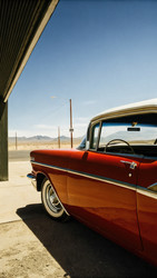 Автомобиль Chevrolet Bel Air припаркован под солнечным небом вдоль живописного маршрута. Генеративный искусственный интеллект - RomanZ