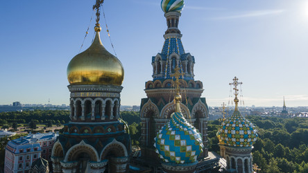 Вид с воздуха крупным планом на купола храма Спаса на Крови рядом с парком в историческом и одновременно современном Санкт-Петербурге на солнечном летнем рассвете - WertigoNice