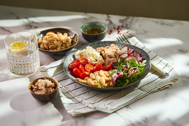 Полезный салат из тунца с белой фасолью, сыром фета, помидорами, редисом и зеленью на мраморном столе - Irrin0215