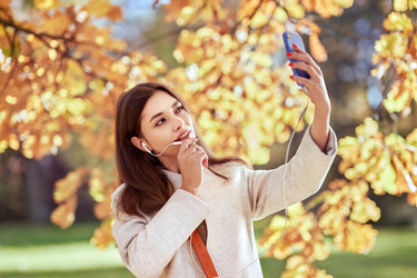 Молодая красивая женщина разговаривает по телефону в осеннем парке - heckmannoleg