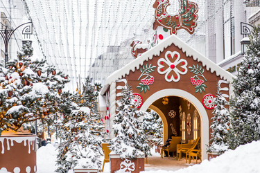 A gingerbread house with a sign among snow‑covered Christmas trees in Kamergersky Lane in Moscow. Concept for the New Year 2027 - PhotoJuli
