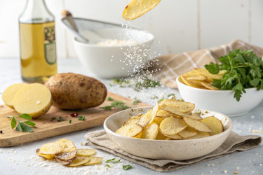 Свежие ломтики сырого картофеля, парящие в воздухе, с оливковым маслом и кухонными ингредиентами в светлой обстановке. Генеративный искусственный интеллект - RomanZ