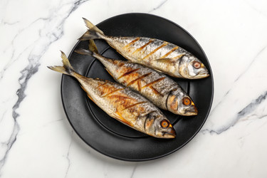 Жареная рыба на черной тарелке. Готово к вкусному обеду. Генеративный ИИ - RomanZ