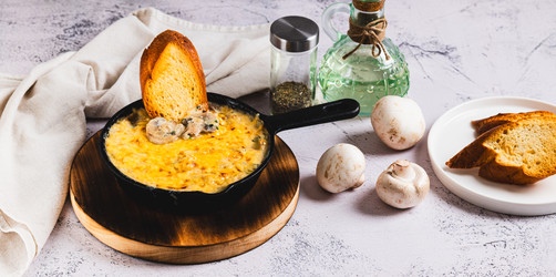 Вкусная нарезанная соломкой колбаса с грибами и сыром, обжаренная на сковороде на столе (веб-баннер) - Elena Rui