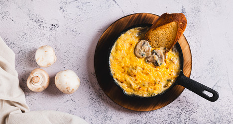 Грибы, нарезанные соломкой, со сливками и сырной корочкой, обжаренные на сковороде на столе (вид сверху, веб-баннер) - Elena Rui