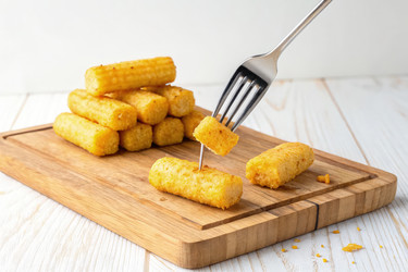 Вкусные золотистые кукурузные палочки на вилке на фоне деревянной разделочной доски и декоративных элементов, демонстрирующих аппетитный момент перекуса. Генеративный ИИ - RomanZ