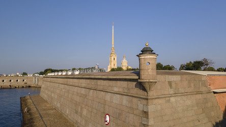 Вид с воздуха на стену Петропавловской крепости, церковь у реки и канал в историческом центре Санкт-Петербурга на солнечном летнем рассвете (вид сбоку) - WertigoNice
