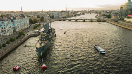 Вид с воздуха на военный корабль «Аврора» в историческом и одновременно современном Санкт-Петербурге летним вечером на закате (в желтых тонах) - WertigoNice