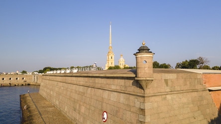 Вид с воздуха на стену Петропавловской крепости, церковь у реки и канал в историческом центре Санкт-Петербурга на солнечном летнем рассвете (вид сбоку) - WertigoNice