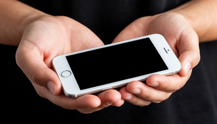 Крупный план рук, держащих белый iPhone, смартфон в ладонях, концепция: технология, мобильное приложение или коммуникация - Kulkann75
