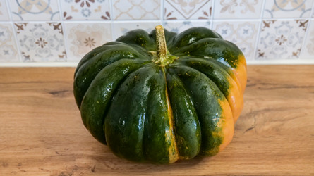 Зеленая тыква на деревянной кухонной столешнице - Gannachka