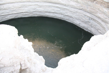 Карстовая воронка Дарваза с изумрудной водой в пустыне Каракум, Туркменистан, под ясным голубым небом - EOS_Canon
