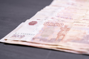 Крупный план российских банкнот номиналом 5000 рублей на темном фоне - AntonSAN