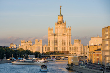 Москва, 26 июля 2026 года. Одно из семи высотных зданий Москвы. Высотное здание на Котельнической набережной в лучах заката, на заднем плане речные суда - AntonSAN