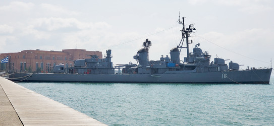 Военный корабль пришвартован у причала. На палубе хорошо видны артиллерийские орудия, башни и мачты с антеннами. Судно находится в спокойной гавани - Dimasik_85