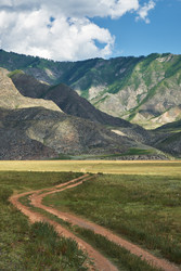 Проселочная извилистая дорога, ведущая через степь в горы. Алтай, Россия - Serg Zastavkin
