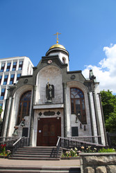 Вид спереди на белый православный храм с золотым куполом и статуей ангела - Patipas
