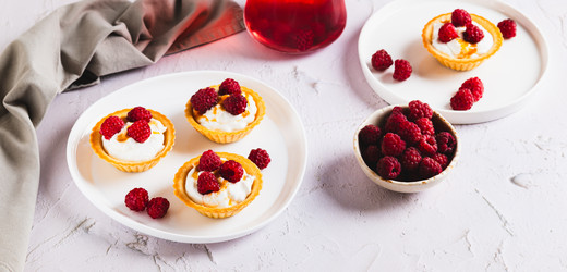 Вкусные тарталетки с рикоттой, джемом и малиной на тарелке на столе (веб-баннер) - Elena Rui