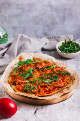Вкусная пицца в пите с помидорами, колбасой, сыром и рукколой на столе (вертикальный вид) - Elena Rui