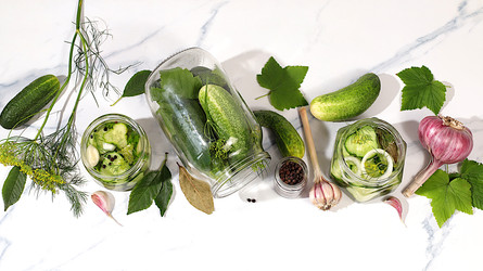Огурцы с укропом, чесноком, хреном, листьями для засолки и маринованные огурцы в банках на кухонном столе. Концепция урожая. Рецепт и ингредиенты для домашних солений. Домашнее консервирование - svetlanabalyn
