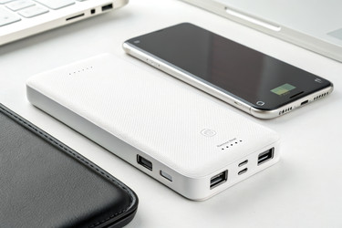 Крупный план зарядных устройств Power Bank на белой поверхности. Генеративный ИИ - RomanZ