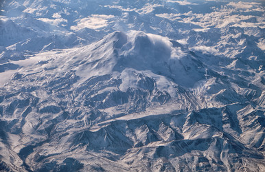 Эльбрус на Кавказе со снежной вершиной на зимнем аэрофотоснимке. Вид с самолета - Serg Zastavkin