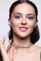 Портрет молодой улыбающейся женщины с голубыми глазами, накрашенными косметикой. На ней ожерелье и серьги. Глаза закрыты - Serg Zastavkin