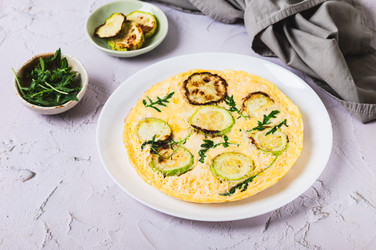 Вкусный омлет из кабачков с сыром и зеленью на тарелке подадут на стол - Elena Rui