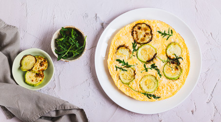 Вкусный омлет из кабачков с сыром и зеленью на тарелке на столешнице посмотреть веб-баннер - Elena Rui